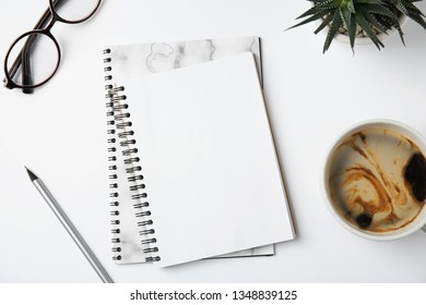 Flat lay composition with notebooks and coffee on white background - Shutterstock ID 1348839125