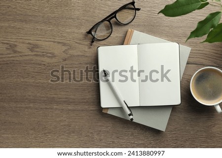Flat lay composition with notebooks and coffee on wooden table. Space for text