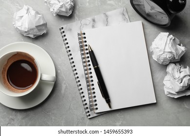 Flat lay composition notebooks and crumpled paper balls on grey marble table. Space for text