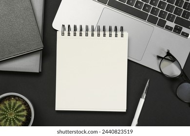 Flat lay composition with notebooks and laptop on black table