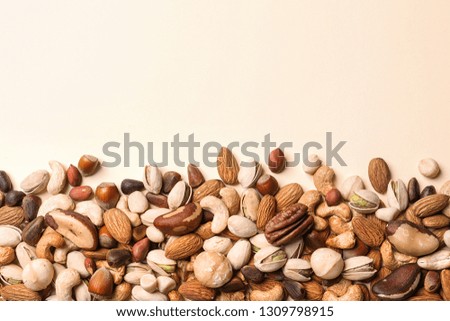 Flat lay composition with organic mixed nuts and space for text on color background