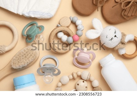 Flat lay composition with pacifiers and other baby stuff on beige background