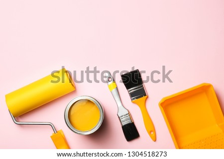 Flat lay composition with paint can, decorator tools and space for text on color background