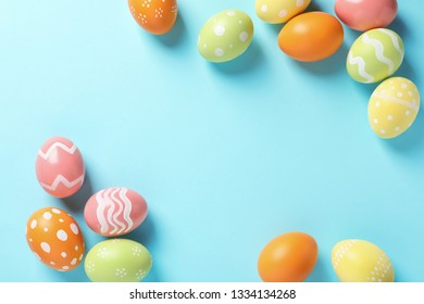 Flat lay composition of painted Easter eggs on color background, space for text