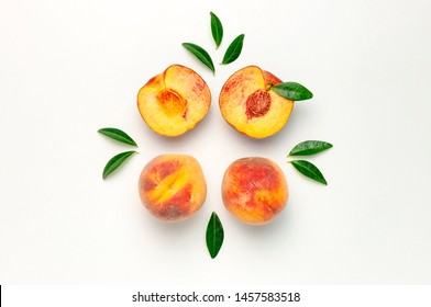 Flat lay composition with peaches. Ripe juicy peaches with green leaves on white background. Flat lay, top view, copy space. Fresh organic fruit, vegan food. Harvest concept.
