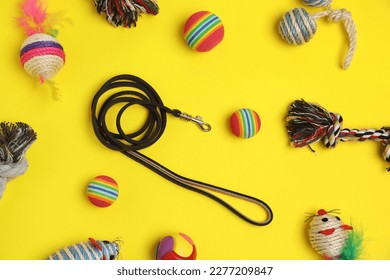 Flat lay composition with pet leash and toys on yellow background