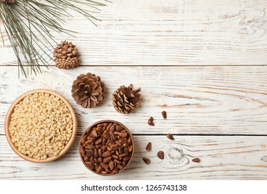 Flat lay composition with pine nuts and space for text on wooden background