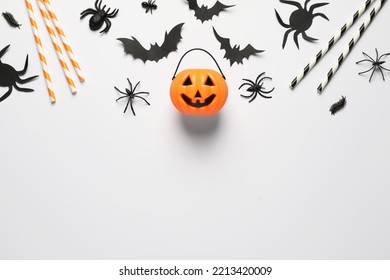 Flat lay composition with plastic pumpkin basket and paper bats on white background, space for text. Halloween celebration - Powered by Shutterstock