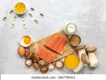 Flat lay composition with products rich in vitamin D. Canned tuna, mushrooms, salmon, eggs, milk, and orange juice - great natural sources of Vitamin D.