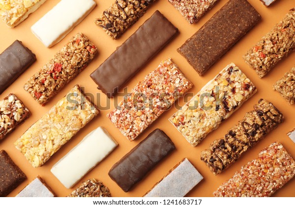 Flat lay composition with protein bars on\
color background