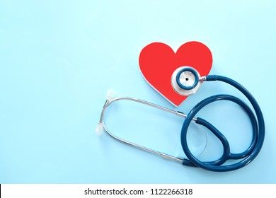 Flat lay composition with red heart and stethoscope on color background, top view