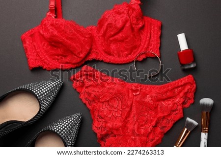 Flat lay composition with red women's underwear and shoes on dark grey background