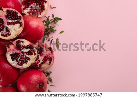 Flat lay composition with ripe pomegranates on pink background. Space for text