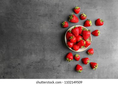 Flat lay composition with ripe red strawberries on grey background