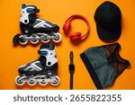Flat lay composition with roller skates on orange background