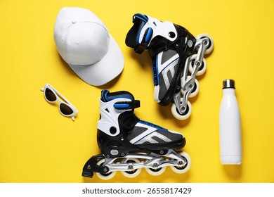 Flat lay composition with roller skates on yellow background