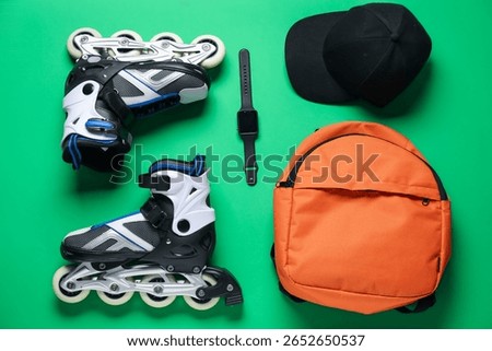 Flat lay composition with roller skates on green background