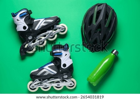 Flat lay composition with roller skates on green background