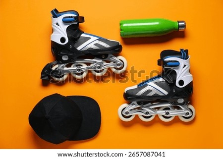 Flat lay composition with roller skates on orange background