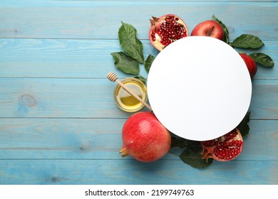 Flat lay composition with Rosh Hashanah holiday attributes and card on light blue wooden table. Space for text