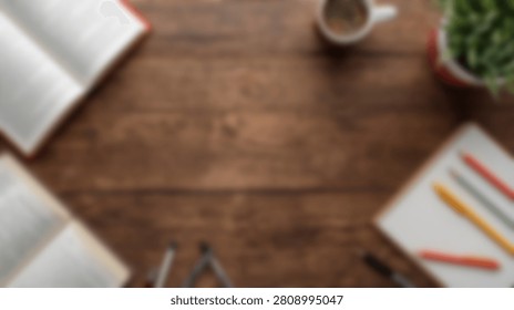 A flat lay composition of a rustic wooden desk surface featuring an open book, a cup of coffee, and colored pencils on a notepad.