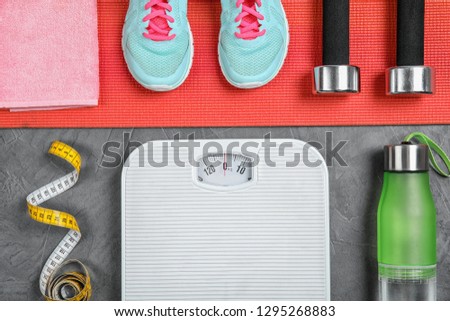 Flat lay composition with scales, measuring tape and sport equipment on gray background. Weight loss