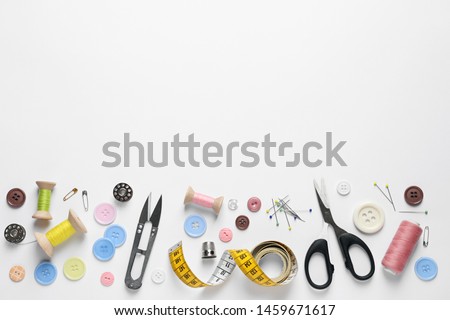 Flat lay composition with scissors and sewing supplies on white background. Space for text