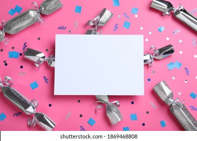 Flat lay composition of silver Christmas crackers with shiny confetti and blank card on pink background. Space for text - Powered by Shutterstock