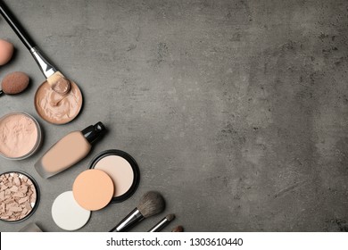 Flat lay composition with skin foundation, powder and beauty accessories on grey background. Space for text