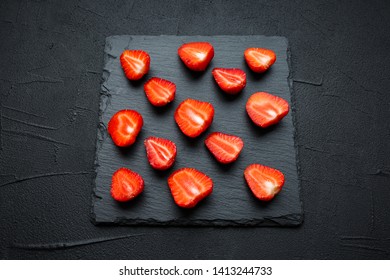 flat lay composition sliced fresh strawberries on dark stone background. top view