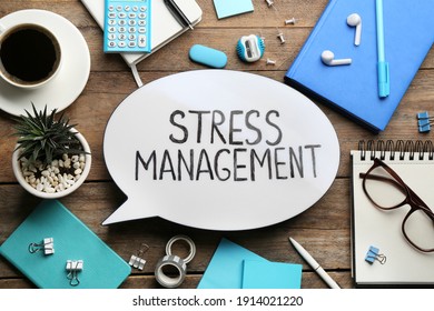 Flat lay composition of speech bubble lightbox with phrase Stress Management on wooden table