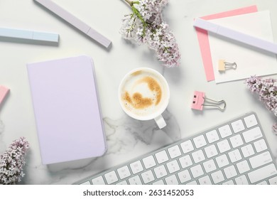 Flat lay composition with stationery, coffee and flowers on white marble table