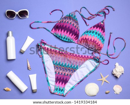 Flat lay composition with stylish bikini on color background