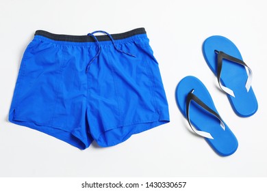 Flat Lay Composition With Stylish Male Swim Trunks On White Background. Beach Objects