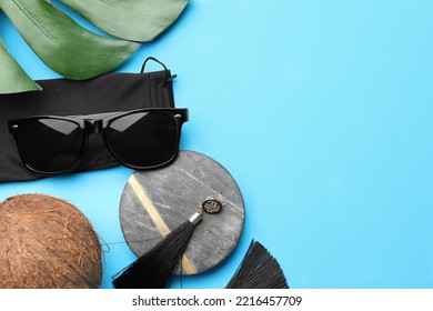 Flat Lay Composition With Stylish Sunglasses And Black Cloth Bag On Light Blue Background. Space For Text