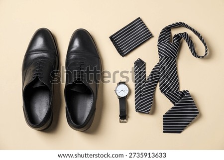 Flat lay composition with stylish tie and shoes on beige background
