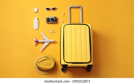 Flat lay composition with suitcase and travel accessories on yellow background. Summer vacation - Shutterstock ID 1903212871