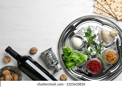 Flat Lay Composition With Symbolic Passover (Pesach) Items And Meal On Wooden Background, Space For Text