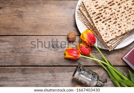 Flat lay composition with symbolic Pesach (Passover Seder) items on wooden table, space for text