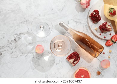 Flat lay composition with tasty rose wine and snacks on white marble table. Space for text