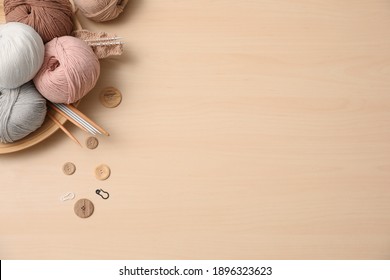 Flat lay composition with threads and crafting accessories on wooden table, space for text. Engaging hobby