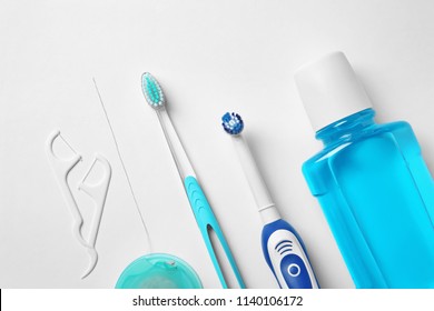 Flat lay composition with toothbrushes and oral hygiene products on white background