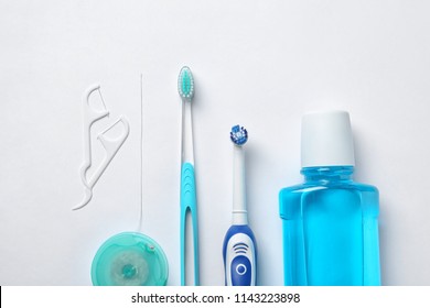 Flat lay composition with toothbrushes and oral hygiene products on white background - Shutterstock ID 1143223898