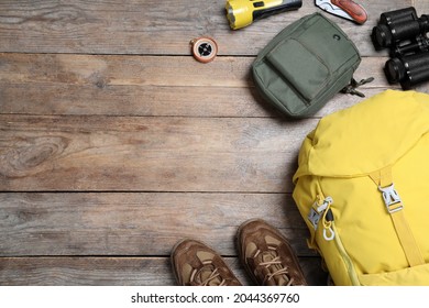 Flat lay composition with tourist backpack and other camping equipment on wooden background, space for text - Powered by Shutterstock