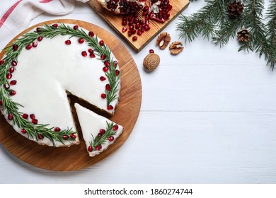 Flat lay composition with traditional Christmas cake on white wooden table. Space for text