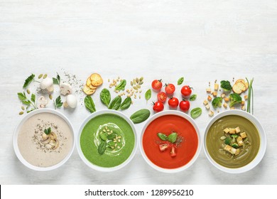 Flat lay composition with various soups, ingredients and space for text on white background. Healthy food