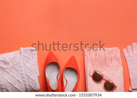 Flat lay composition with warm clothes on coral background. Space for text