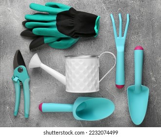 Flat lay composition with watering can and gardening tools on light grey background