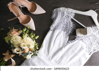 Flat lay composition with white wedding dress on grey stone table