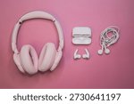Flat lay composition of wireless over ear headphones, wireless earbuds and wired earphones on a pink background. Audio technology concept with copy space for advertising or branding.
